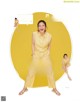 A woman in a yellow shirt and yellow pants posing for a magazine.