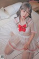 a woman in a white dress sitting on a bed