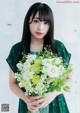 A woman holding a bouquet of flowers in her hands.