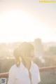 A woman in a white shirt standing on top of a roof.