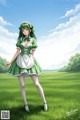 A girl in a green dress standing in a field.