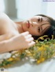 A woman laying on top of a bed covered in flowers.